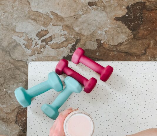 피트니스 목표 설정: 달성을 위한 전략과 방법 person holding white liquid filled cup above two pairs of dumbbells