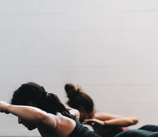 체중 감소를 위한 HIIT 운동 woman in black tank top and black leggings lying on black floor