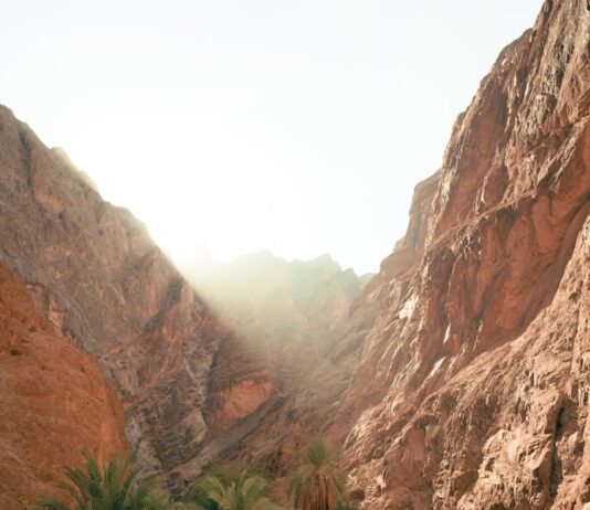 야외 활동으로 건강과 다이어트 함께 달성 a man walking down a dirt road next to a mountain