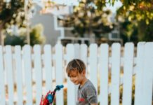 ‘찾아가는 어린이 자전거 교통 안전교육’ 실시 girl in red and black bicycle suit standing beside white wooden fence during daytime