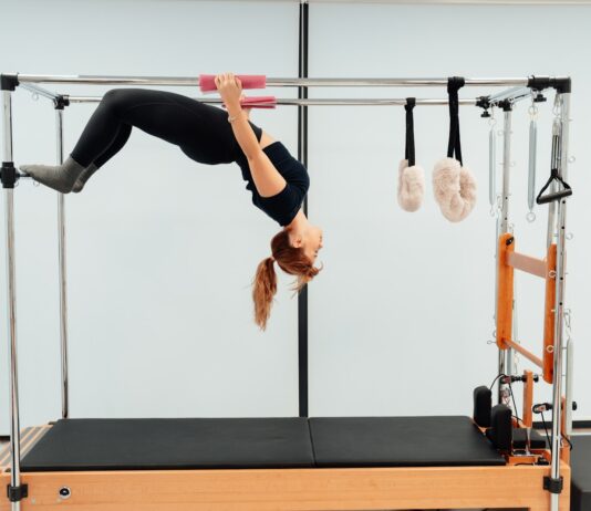 필라테스와 스트레칭의 차이점과 장점 a woman doing a handstand on a pivot machine