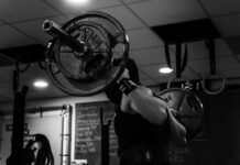 운동이 노화 방지에 미치는 효과 grayscale photo of man lifting barbell