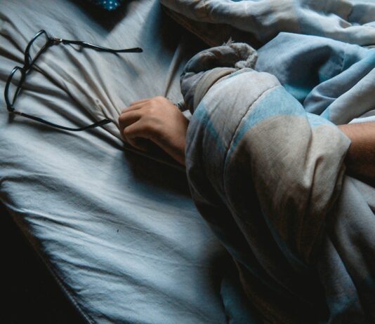 하루 종일 지친다면, 만성피로 증후군을 의심해보세요 black framed eyeglasses on blue bedsheet