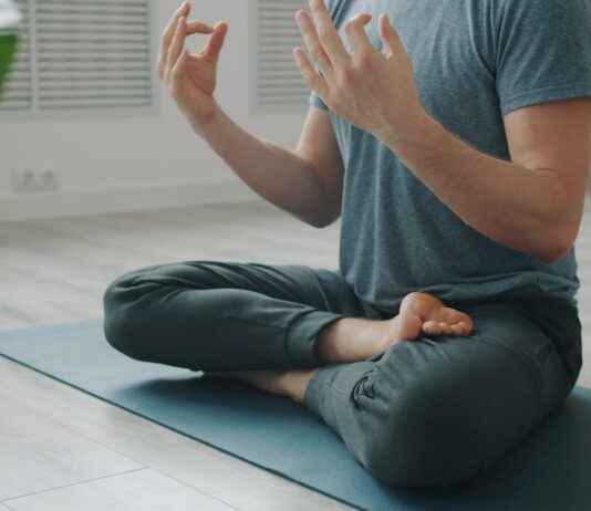 과도한 자기관리의 역설: 건강을 쫓을수록 멀어지는 이유 Man meditating in lotus pose on yoga mat.