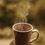 만성피로, 바쁜 일상 속 작지만 확실한 변화로 개선한다 a steaming cup of coffee sitting on top of a wooden table