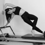 홈트족의 반란: 유튜브 보고 따라 하던 필라테스, 왜 내 허리는 더 아플까? woman in black sports bra and black leggings doing yoga