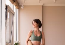 일상 속 필라테스, 내 몸에 맞는 맞춤 건강법으로 뜬다 a woman in a green sports bra top and leggings holding a yoga mat